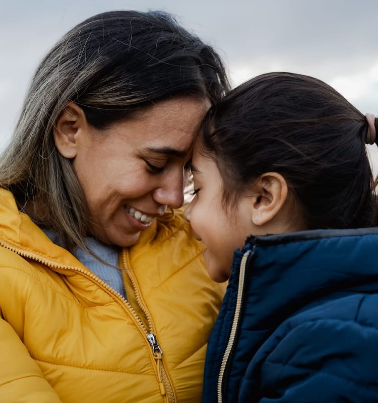 happy-latin-mother-with-her-daughter-having-tender